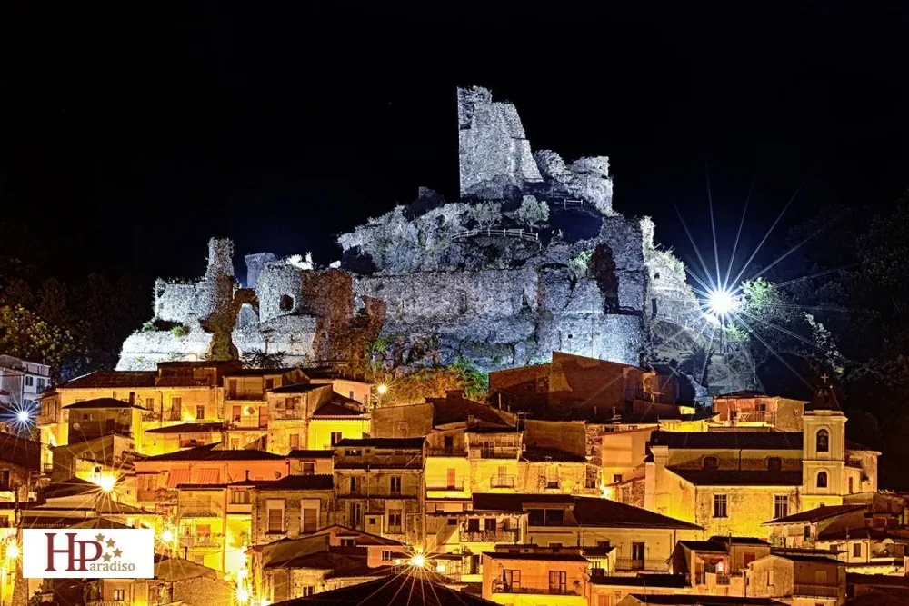 Castello Normanno-Svevo illuminato sopra le case di Nicastro