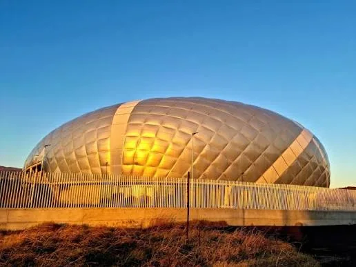 Copertura del nuovo Palazzetto dello Sport di Lamezia Terme illuminata al tramonto