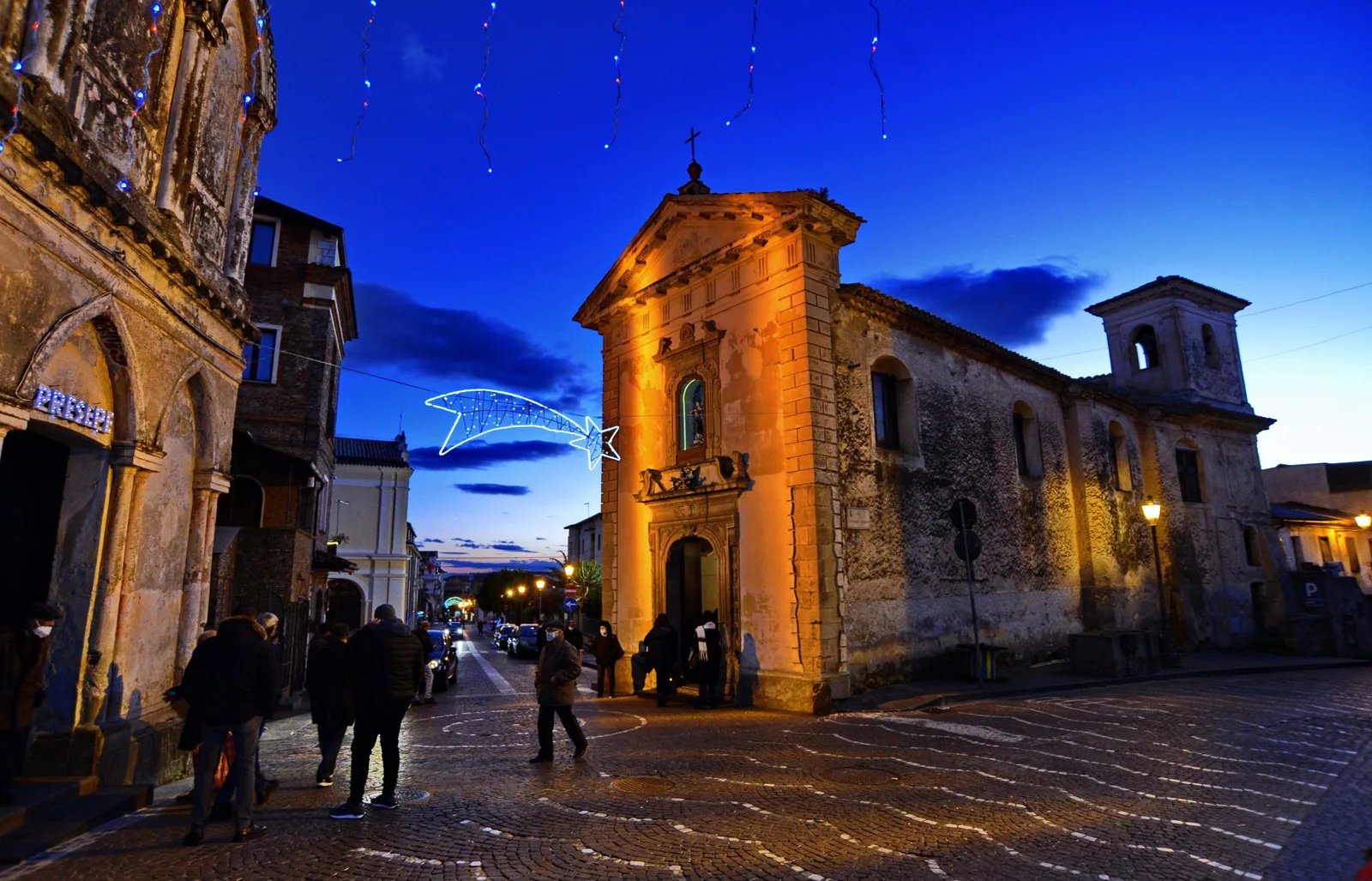 Chiesa storica illuminata al crepuscolo in una piazza di Lamezia Terme