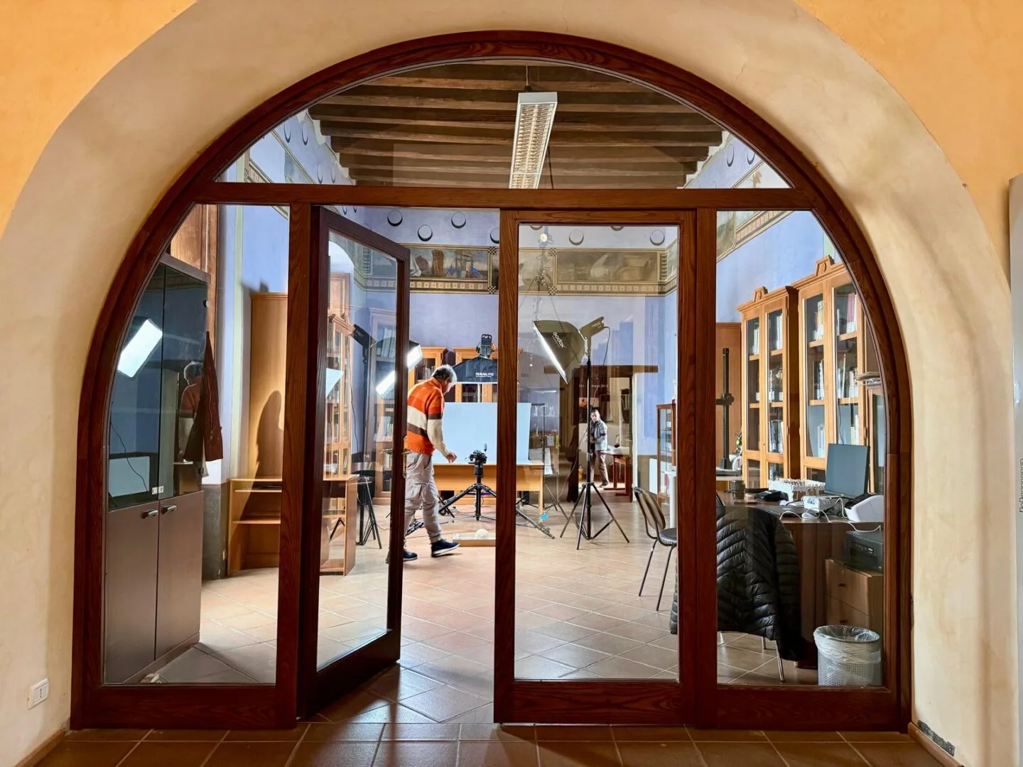 Sala interna di uno spazio culturale con vetrine e librerie