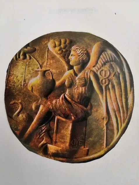 Medaglione antico con figura alata e simboli