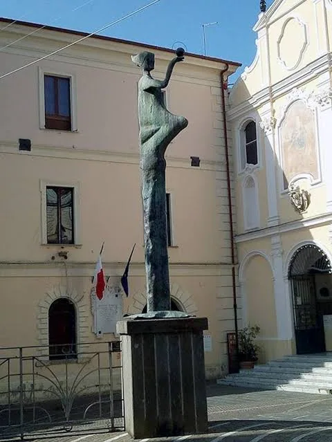 Statua femminile in bronzo in una piazza storica