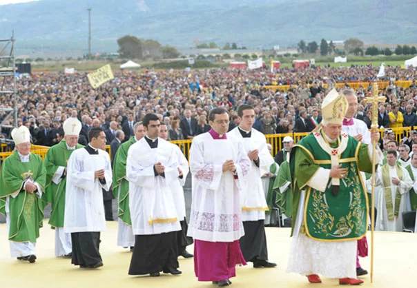 Celebrazione religiosa all'aperto con una grande folla